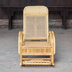 a wooden rocking chair sitting on top of a cement floor