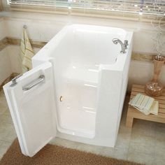 a bathroom with a walk in tub next to a wooden table and window sill