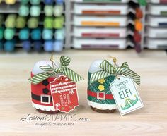 two christmas ornaments sitting on top of a wooden table