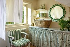 a green and white striped chair sitting in front of a window next to a table