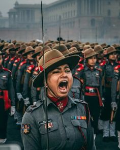 a group of women in uniform singing and marching down the street with their mouths open