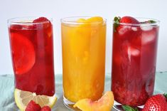 three glasses filled with different types of fruit juices and garnishes on a table