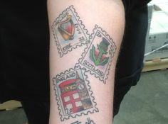 a person with a tattoo on their arm has four stamps that say england and scotland