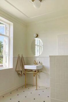 a bathroom with a sink, mirror and towel rack on the wall in front of a window