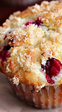 a close up of a muffin with crumbled toppings on a table