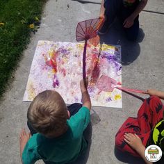 two children are painting on the sidewalk with their hands and legs, while one child is holding a net