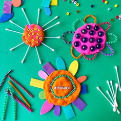 some crafting supplies are laying out on a green surface with scissors and pins in the middle