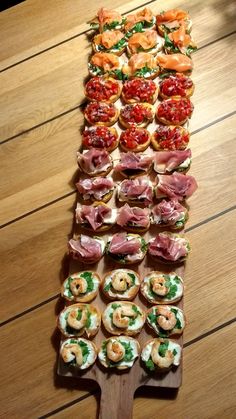 a wooden table topped with lots of different types of appetizers on top of it