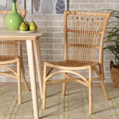 two wicker chairs sitting next to each other near a table with pears on it