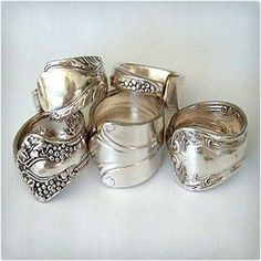 a group of silver rings sitting on top of a white table