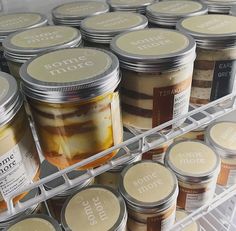 several jars of food sitting on top of a refrigerator freezer filled with ice cream