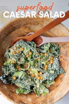 a wooden bowl filled with green vegetables on top of a table