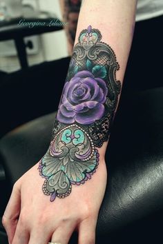 a woman's hand with a purple rose tattoo on it and an ornate frame around the wrist