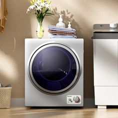 a washing machine sitting on top of a wooden floor next to a dryer and towel dispenser