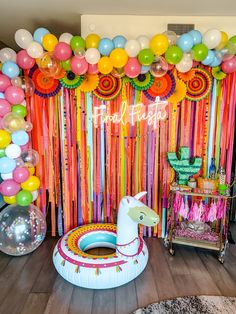 a birthday party with balloons, streamers and an inflatable llama on the floor