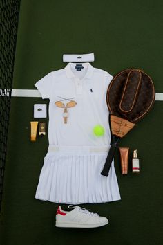 a tennis outfit and racket are laid out on the court