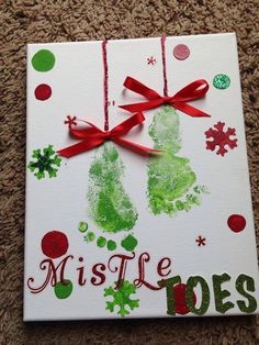 a christmas card with handprints and red ribbon on it that says, mistle toes