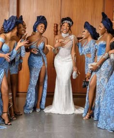 a group of women in blue dresses standing next to each other with their arms around one another