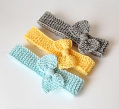 three crocheted headbands with bows on them sitting next to each other