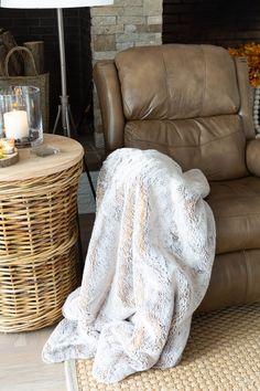 a living room with a couch, chair and table covered in a white fluffy blanket