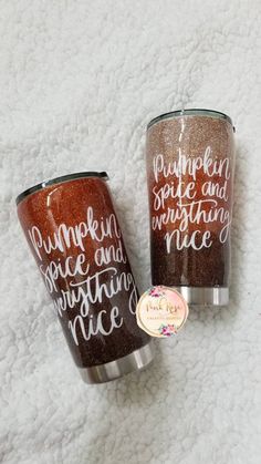 two tumblers with the words pumpkin spice and everything nice on them are sitting on a white surface