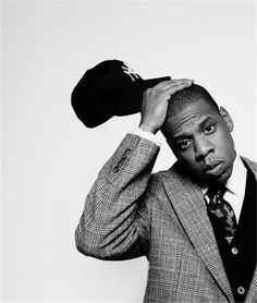 a black and white photo of a man in a suit with a hat on his head