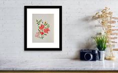 a white brick wall with a painting on it next to a potted plant and a camera