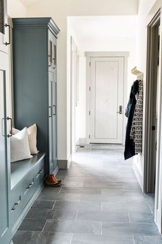 a long hallway with blue cabinets and gray tile flooring is pictured in this image