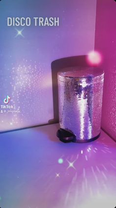 a disco trash can sitting on top of a white counter next to a purple wall