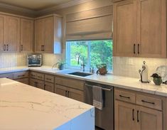 a kitchen with marble counter tops and wooden cabinets