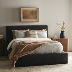 a bedroom with a bed, nightstands and pictures on the wall above it is shown