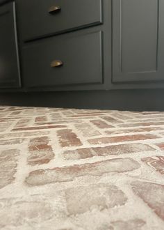 a close up of a kitchen floor with brown and white tiles on it's surface