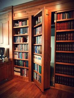 an open bookcase with many books on it in a room filled with wooden floors