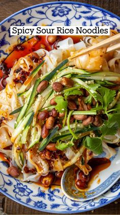 a blue and white bowl filled with food next to chopsticks on top of a wooden table