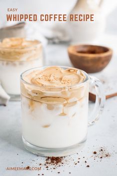 two mugs filled with whipped coffee on top of a table