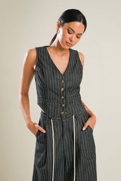 Unleash your inner fashionista with our Terra Black Denim Striped Vest. This trendy vest features a flattering V neckline, stylish striped denim design, and convenient button down closure. The sleeveless cut and faux pockets add a touch of edginess while the 90% cotton and 10% polyester blend ensures both comfort and durability. Elevate any outfit with this must-have vest. Trendy Vest, Striped Vest, Striped Denim, Kimono Sweater, Striped Vests, Pants Details, Trendy Outfit, Matching Pants, Denim Design