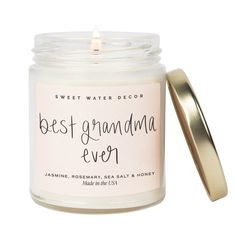 the best grandma ever soy candle is in a glass jar with a gold lid and an empty