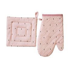 two oven mitts are sitting next to each other on a white background, one is pink and the other has black dots