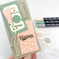 a hand holding up a card that says hooray with some stamps on it