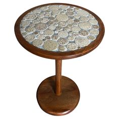 a small wooden table with white and brown stones on it's top, against a white background