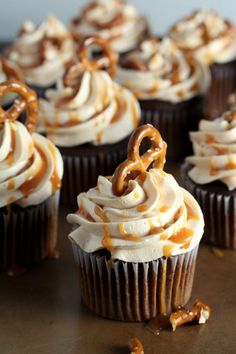 chocolate cupcakes with white frosting and pretzels on top, ready to be eaten