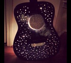 an acoustic guitar with stars and lights on it