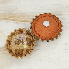 two cupcake tins sitting next to each other on a white table with a piece of cake in the middle