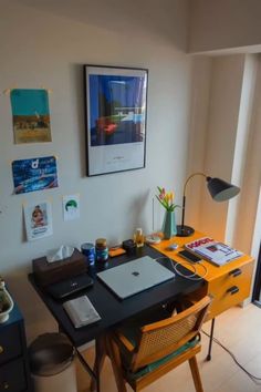 a desk with a laptop computer on top of it in front of a large window