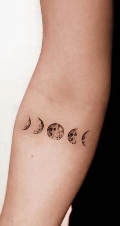 a woman's arm with three phases of the moon tattoo