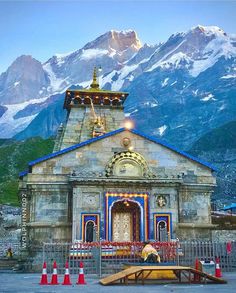 an old church with mountains in the background