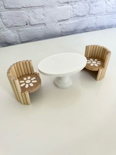 two chairs and a table on a white surface