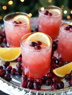 three glasses filled with cranberry lemonade and garnished with orange slices