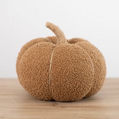 a stuffed pumpkin sitting on top of a wooden table