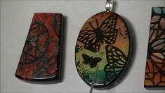 three pendants with different designs on them hanging from a white wall next to each other